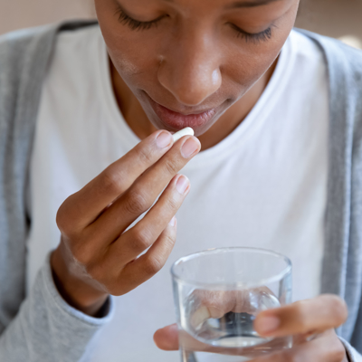 Young Black woman taking tablet
