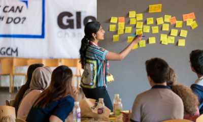 Person standing at a whiteboard in front of a group sitting at a table