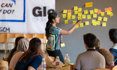 Person standing at a whiteboard in front of a group sitting at a table