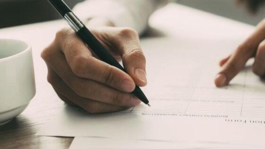 person writing on documents