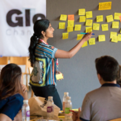 Person putting post-it notes on board in front of group