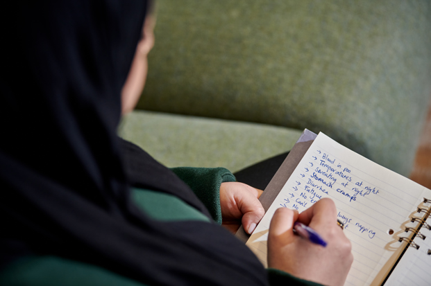 Woman writing list of symptoms