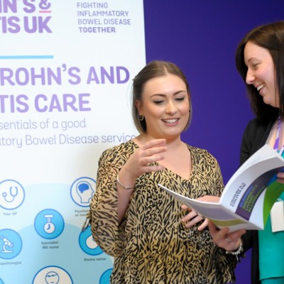 Two people talking and looking at a booklet. 