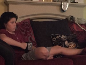 Ben holding a mug while laying on a sofa.