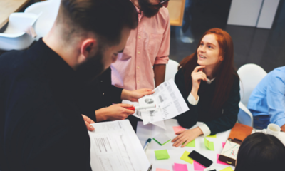 Group of people in a workshop talking around a table.