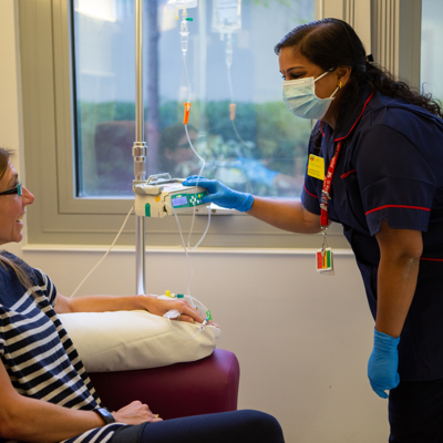 Woman having infusion chatting with nurse