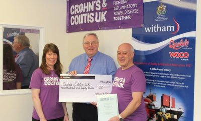 Crohn's & Colitis UK supporters wearing purple t-shirts being presented with a cheque