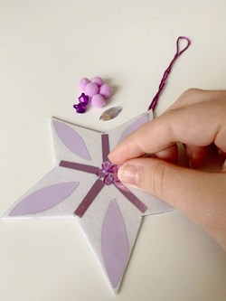 Sticking a flower on to the middle of a star decoration.