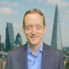 Headshot of Iain Kemp in front of a London cityscape backdrop.